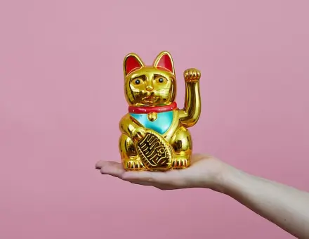 写真:手の上に金色の招き猫が乗っています